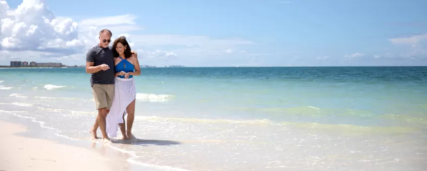 couple walking down bonita beach